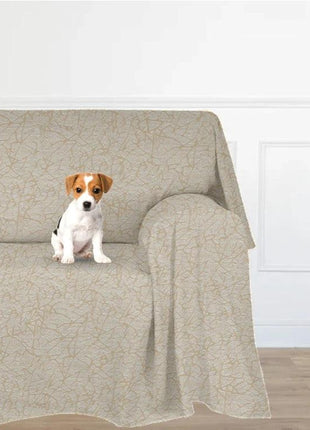 Telo Arredo Salva Divano Antimacchia RIO beige med uregelmæssigt linjemønster; hvalp siddende på sofaen.